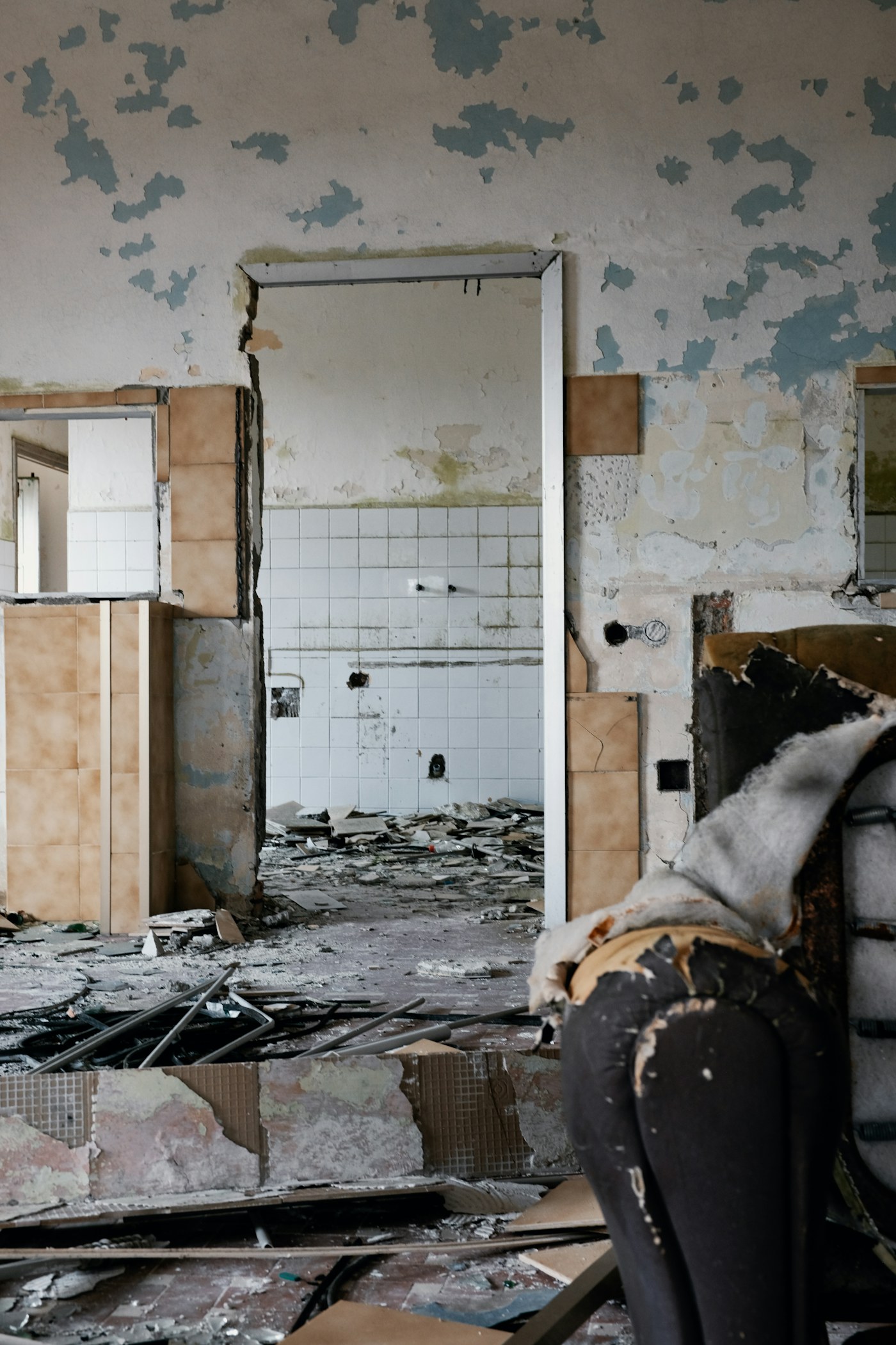 Interior wall with damaged paint, tile, and moisture stains